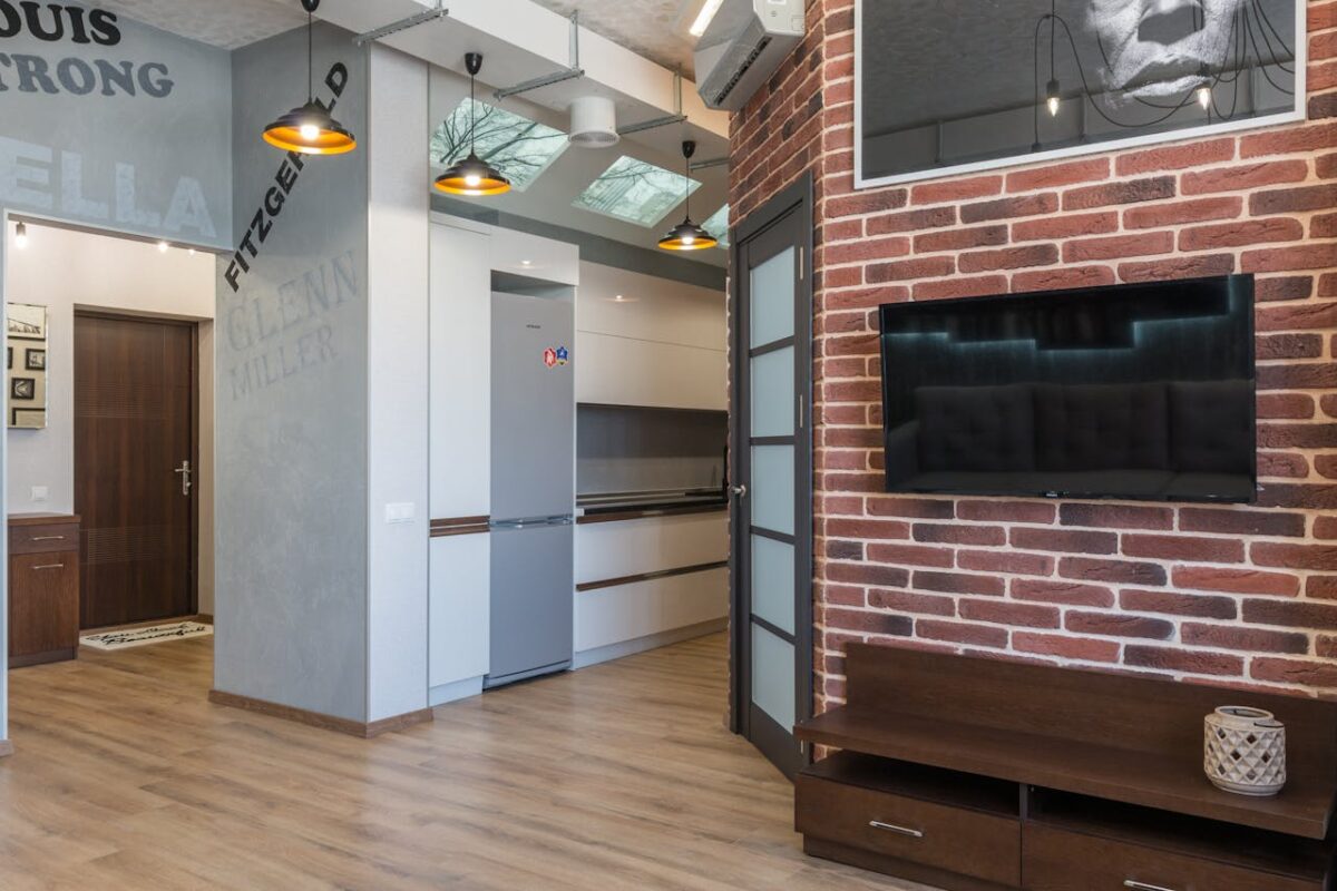 A contemporary home interior featuring a brick wall with a sleek TV setup.